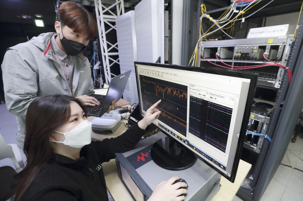 서울 KT 융합기술원에 구축된 오픈랜 테스트베드에서 KT 연구원과 후지쯔 연구원이 멀티벤더 연동 시험을 진행하고 있다.